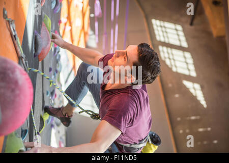 L'athlète de climbing rock wall in gym Banque D'Images