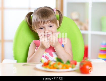 Petite fille aux aliments légumes showing thumb up Banque D'Images