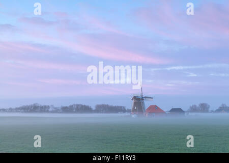 Moulin à vent hollandais au lever du soleil brumeux, Holland Banque D'Images