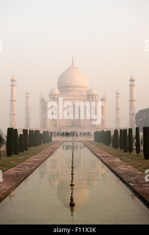 Agra, Uttar Pradesh, Inde. Le Taj Mahal vu de la fin de l'al Hawd al-Kawthar réservoir, avec sa réflexion, dans la brume matinale. Banque D'Images