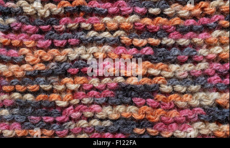 Close-up de lignes horizontales de garter stitch en rouge, noir, orange et marron laine comme une texture de fond abstrait Banque D'Images