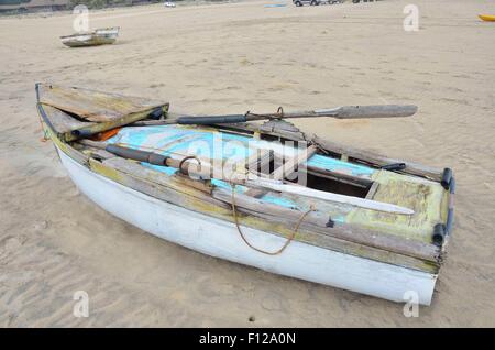 Cet ancien bateau de pêche non sécuritaires, allongé sur la plage à Inhambane, Mozambique est en utilisation quotidienne. Banque D'Images