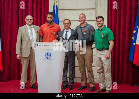 Paris, France. Août 24, 2015. Le Président français François Hollande, centre, pose avec les quatre hommes qui ont déjoué un attentat terroriste contre un train français après l'attribution de la Légion d'honneur à l'Elysée le 24 août 2015 à Paris, France. (L à R) : homme d'affaires britannique Chris Norman, Anthony Sadler Spencer Stone et Aleksander Skarlatos. Banque D'Images