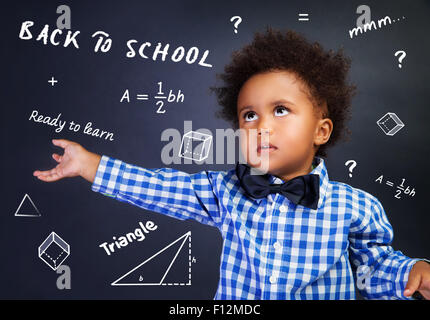 Portrait of African American curly smart écolier à l'école sur Leçon de mathématiques, près de la tâche de résolution tableau noir Banque D'Images