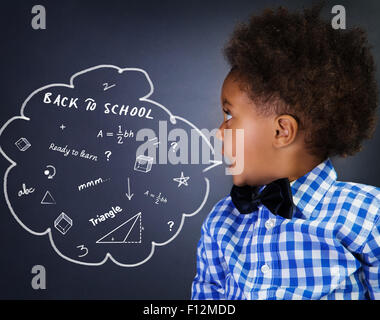 Portrait of African American curly smart écolier à l'école sur Leçon de mathématiques, près de la tâche de résolution tableau noir Banque D'Images