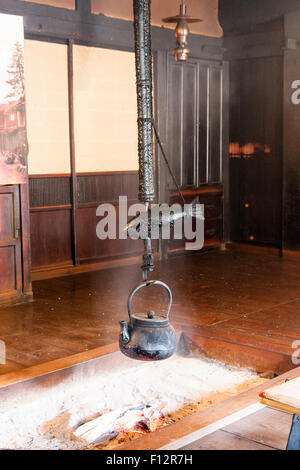 Magome, au Japon. La route Nakasendo, intérieur de la période Edo avec Irori traditionnelle resthouse, foyer en marbre et pendaison pot, Jizaikagi, ci-dessus. Banque D'Images