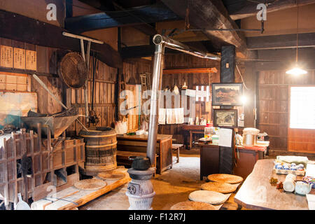 Magome, au Japon. L'intérieur d'une période Edo resthouse sur la route Nakasendo. Chambre principale avec petit s'est efforcé encombrés, des meubles et du tuyau de cheminée Banque D'Images