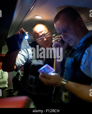 Mauvais Gottleuba-Berggiesshuebel, Allemagne. Août 24, 2015. Les agents de police Patrick Thomas et Torsten Bastian (L) vérifier les passagers d'un bus à une aire de repos d'autoroute pendant un quart de nuit à mauvais Gottleuba-Berggiesshuebel, Allemagne, 24 août 2015. PHOTO : ARNO BURGI/DPA/Alamy Live News Banque D'Images