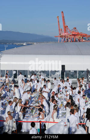 Vancouver, Canada. Août 25, 2015. Des gens habillés en blanc ont un dîner à la salle à manger en blanc à la Place du Canada, à Vancouver, Canada, le 25 août, 2015. Environ 4 500 personnes ont participé à l'événement à Vancouver pour profiter d'un dîner en plein air spécial. Diner en Blanc est une sorte de flash mob événement. Les participants sont nécessaires pour porter en blanc et se rassembler dans un lieu secret n'étant pas annoncé jusqu'à deux heures avant le début de la manifestation. Le Diner En blanc a eu lieu en France en 1988 pour la première fois et maintenant a eu lieu dans plus de 60 villes à travers le monde. Credit : Liang Sen/Xinhua/Alamy Live News Banque D'Images