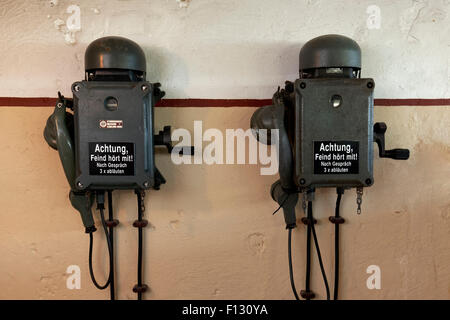 Deux téléphones dans un bunker de la seconde guerre mondiale, avec l'inscription, l'ennemi est à l'écoute, en allemand Banque D'Images