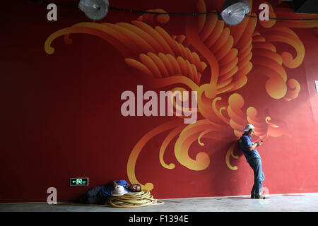 Beijing, Chine. Août 26, 2015. Le repos des travailleurs dans l'ombre pendant la pause de l'après-midi à Beijing 2015 les championnats du monde IAAF au Stade National, également connu sous le nom de nid d'oiseau, à Beijing, Chine, 26 août 2015. Photo : Christian Charisius/dpa/Alamy Live News Banque D'Images