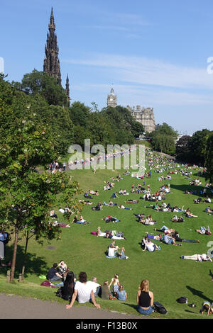 Des gens assis et couché au soleil, les jardins de Princes Street, Édimbourg Banque D'Images