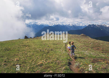 Garçon et fille courir le long d'un sentier de montagne Banque D'Images