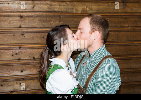 Bavarian couple relaxing in front of wooden wall Banque D'Images