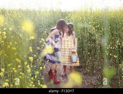 Deux jeunes filles avec des seaux Picking Flowers Banque D'Images
