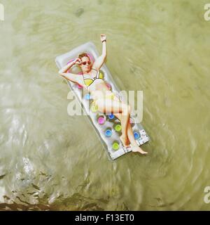 Vue aérienne d'une femme couchée sur un matelas gonflable dans la mer Banque D'Images