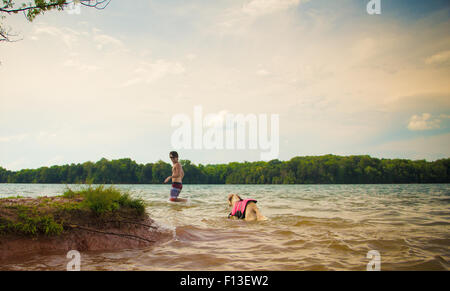 L'homme et le chien marche dans un lac, Loudon, New York, USA Banque D'Images