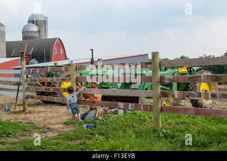 Garçon aidant père on farm Banque D'Images