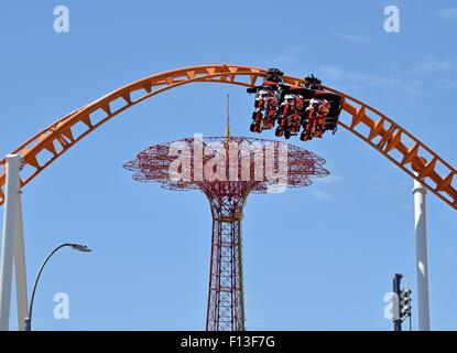 Les usagers de la Thunderbolt dans Coney Island, Brooklyn, New York. Le saut en parachute est dans l'arrière-plan. Banque D'Images