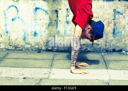 Exécution d'un danseur de hip-hop en face d'un mur de graffiti. Banque D'Images