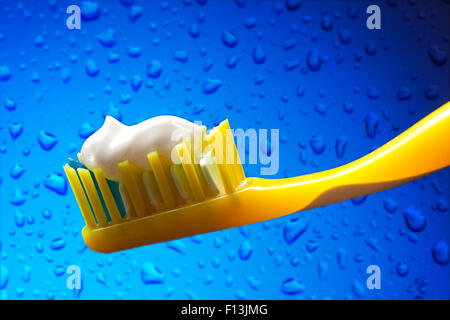 Brosse à dents et dentifrice sur fond de l'eau bleue Banque D'Images