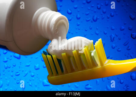 Brosse à dents et dentifrice sur fond de l'eau bleue Banque D'Images