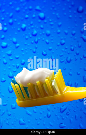 Brosse à dents et dentifrice sur fond de l'eau bleue Banque D'Images