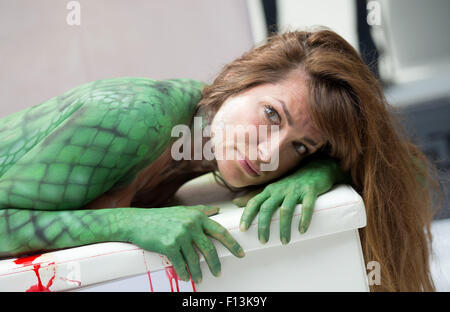 Hambourg, Allemagne. Août 26, 2015. L'actrice Alexandra Kamp portant des crocos comme peinture corporelle se trouve devant un magasin de vêtements français fabricant Hermes au cours d'une campagne d'organisation de défense des droits des animaux Peta contre les sacs à main de luxe en cuir de crocodile à Hambourg, Allemagne, 26 août 2015. Photo : DANIEL REINHARDT/dpa/Alamy Live News Banque D'Images