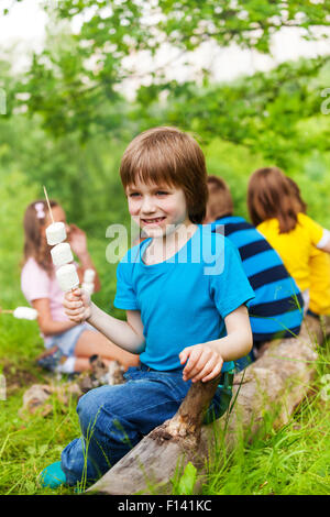 Petit positif boy holding stick avec des guimauves Banque D'Images