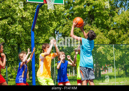 Groupe d'adolescents jouer au basket-ball sur l'aire de jeux Banque D'Images