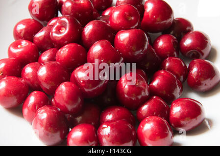 Bol d cerries frais rouge sur fond blanc Banque D'Images