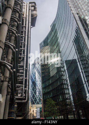 Slkies orageux et ensoleillé s'allumer le Gherkin et la Lloyds Building dans la ville de Londres et l'église St.Andrew Undershaft Banque D'Images