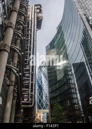 Slkies orageux et ensoleillé s'allumer le Gherkin et la Lloyds Building dans la ville de Londres et l'église St.Andrew Undershaft Banque D'Images