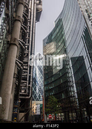 Slkies orageux et ensoleillé s'allumer le Gherkin et la Lloyds Building dans la ville de Londres et l'église St.Andrew Undershaft Banque D'Images