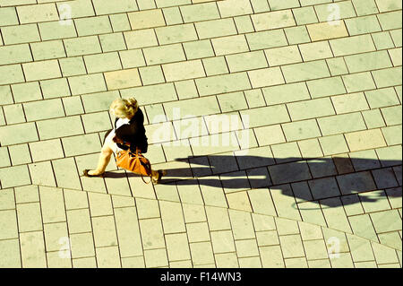 Femme marche sur la rue, projetant une ombre. Vue d'en haut Banque D'Images