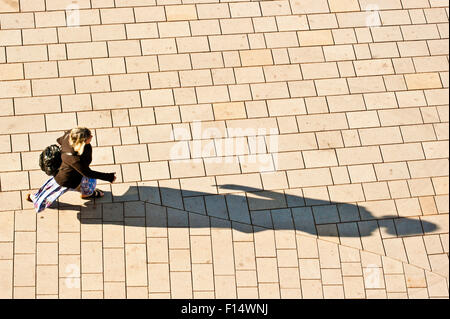 Femme marche sur la rue, projetant une ombre. Vue d'en haut Banque D'Images