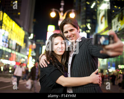 USA, New York City, Manhattan, Times Square, Young couple photographing themselves Banque D'Images