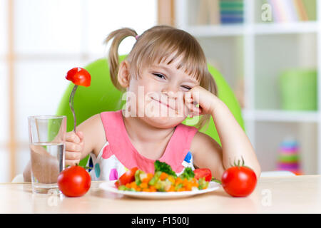 Petite fille à l'expression de dégoût contre tomato Banque D'Images