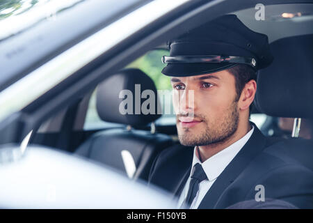 Portrait d'un beau mâle assise dans une voiture avec chauffeur Banque D'Images