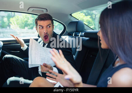 Angry Man holding documents crier sur une femme dans... Banque D'Images