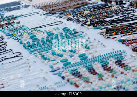 Perles Turquoise sont utilisés pour fabriquer des colliers qui pondent dans les lignes de bijoux sur une nappe blanche à un marché en plein air. Banque D'Images