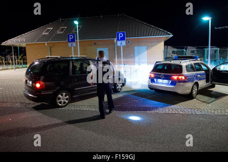 Les agents de police Torsten Bastian (non représenté) et Patrick Thomas vérifier l'identité des passagers dans un véhicule pendant leur quart de nuit sur l'aire de repos 'Am Heidenholz' près de la station de police fédérale Breitenau à Bad Gottleuba-BerggieSShuebel, Allemagne, 24 août 2015. Photo : ARNO BURGI/dpa Banque D'Images