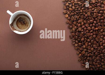 Tasse de café bu avec les grains de café sur fond brun.vue ci-dessus Banque D'Images