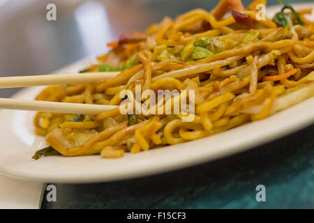 La consommation de porc lo mein Nouilles chinoises avec des baguettes Banque D'Images