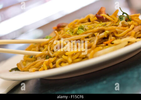 La consommation de porc lo mein Nouilles chinoises avec des baguettes Banque D'Images