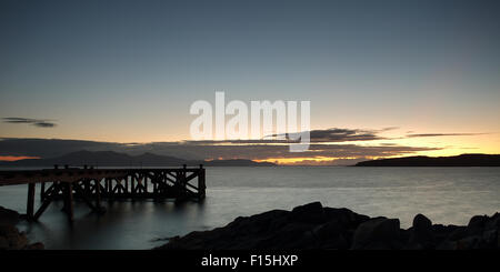 Portencross Pier au coucher du soleil, à travers la mer est l'île d'Arran Banque D'Images