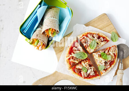 Des pizzas sur une planche à découper et en bonne santé, les couches au sandwich contenant, studio shot on white background Banque D'Images