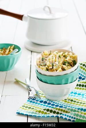 Farfalle aux pois et à la menthe dans une pile de bols avec pot en background, studio shot Banque D'Images