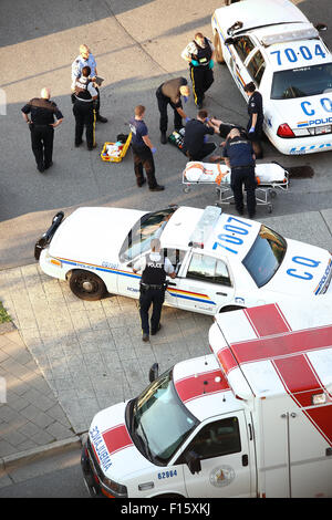 Le personnel médical et la police d'aider l'homme d'une crise cardiaque dans la rue. Banque D'Images