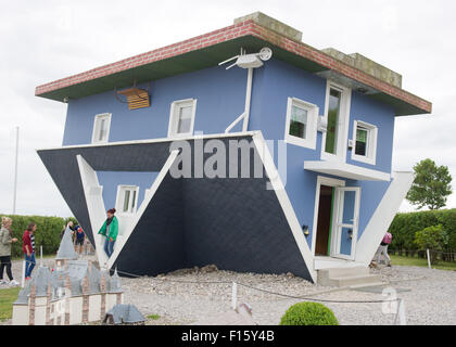 Wolgast, Allemagne. Août 25, 2015. Les visiteurs se tenir en face d'une maison qui est à l'envers à Wolgast, Allemagne, 25 août 2015. Deux hommes d'affaires de Stettin en Pologne construit la maison sur l'île Usedom en 2008. Le projet 'Die Welt steht Kopf" (lit. 'Le monde est à l'envers') est devenu un aimant pour les visiteurs et attire jusqu'à 50 000 visiteurs par an. Photo : STEFAN SAUER/dpa/Alamy Live News Banque D'Images